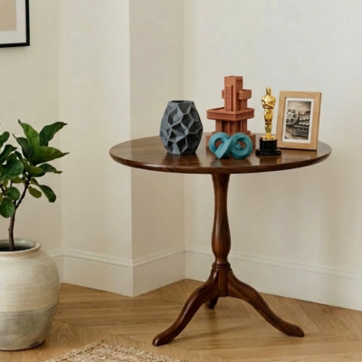 Mesa redonda de madeira com objetos decorativos e planta junto