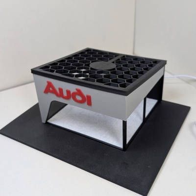 Modelo 3D com logo Audi em relevo vermelho e grelha hexagonal preta no topo