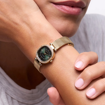 Relógio feminino dourado com mostrador verde escuro e pedras brilhantes no pulso