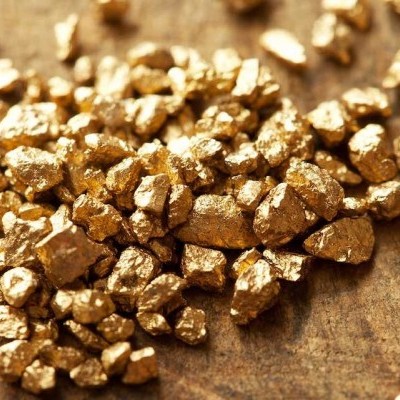 Pepitas douradas pequenas sobre madeira