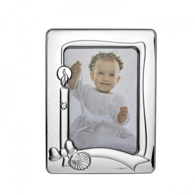 Moldura prateada com decoração de vela, laço e sino e fotografia de bebé