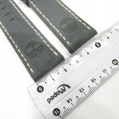 Correia de relógio em couro preto com coutos brancos e logotipo próximo a régua