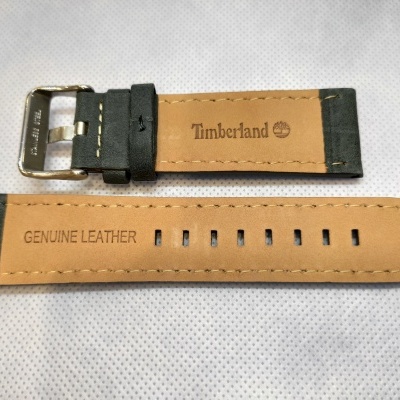 Correia para relógio de pele castanha clara e preta com inscrições 'Timberland' e 'GENUINE LEATHER'.
