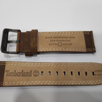 Bracelete de relógio em couro castanho com marcações e fivela preta sobre fundo branco