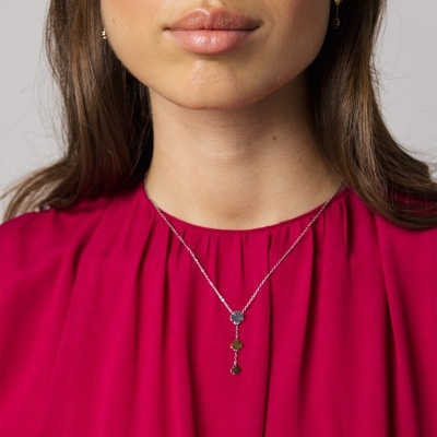 Colar prateado com pedras coloridas usado por mulher com blusa vermelha