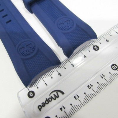 Correia azul de relógio em silicone ao lado de régua branca transparente