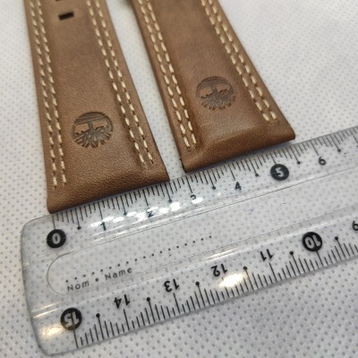 Tiras de couro castanho com costura clara e régua transparente ao lado
