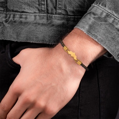 Bracelete preto com detalhe dourado em pulso masculino