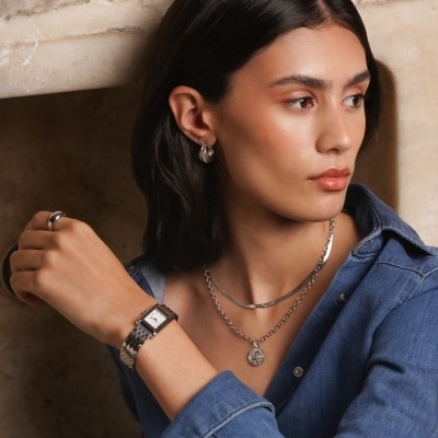 Relógio de pulso feminino com bracelete em couro castanho e mostrador retangular branco.