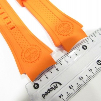Tiras laranja de borracha ao lado de régua transparente