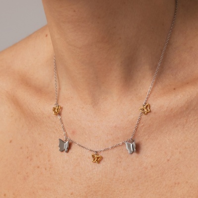 Colar com pendentes de borboletas douradas e prateadas no pescoço