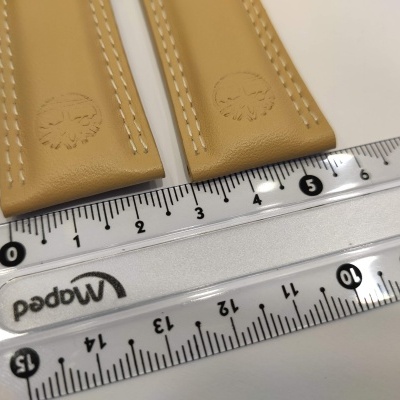 Braceletes de relógio em couro castanho claro junto a régua transparente