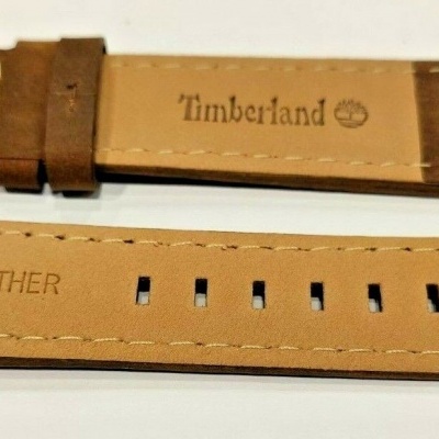 Correia de relógio em couro castanho clara com fivela prateada e inscrições Timberland e GENUINE LEATHER