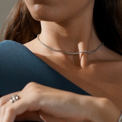 Colar fino prateado com brincos e anel, roupa azul escura