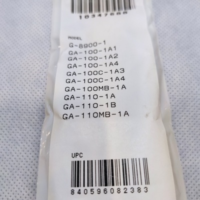 Etiqueta branca com lista de modelos e códigos de barras numa embalagem branca