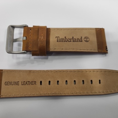 Correia de relógio em pele castanha clara com fivela metálica prateada e texto Timberland e GENUINE LEATHER
