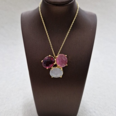 Colar dourado com três pedras coloridas em busto marrom