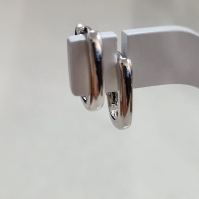 Brincos de argola pequenos em metal prateado em pendurador branco