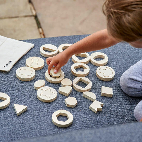 Formas de Madeira Dentro e Fora Peças de madeira com formas geométricas sobre tecido cinzento