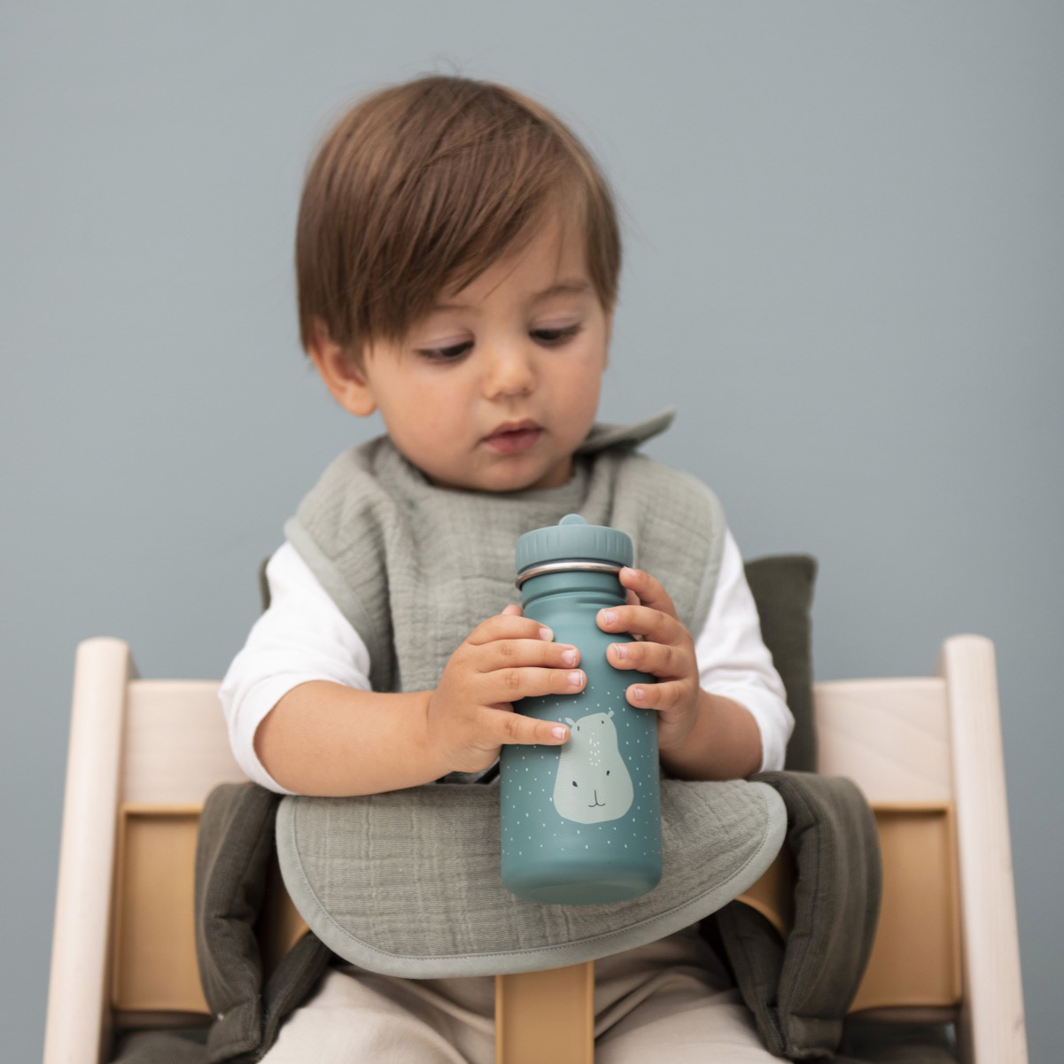 Bottle 350ml Criança com babete cinza segurando copo azul com desenho