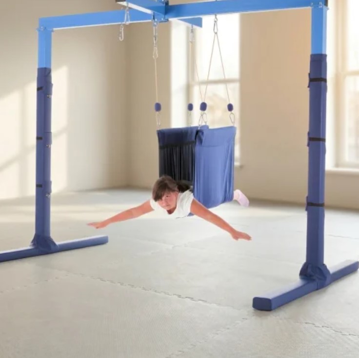 Baloiço Taco Sensory Swing – Sensory Taco Swing – Large Estrutura azul com assento suspenso e criança deitada
