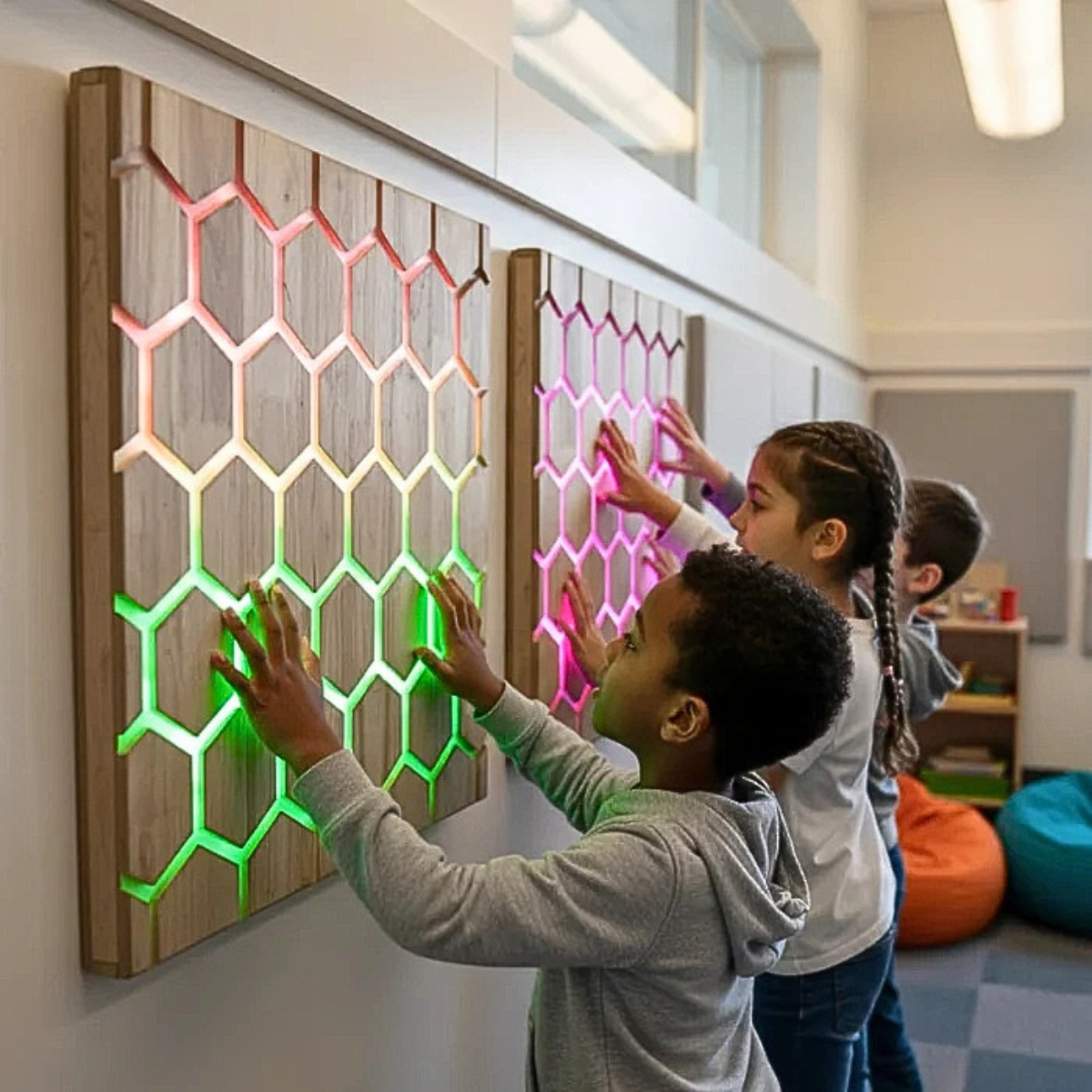 Painel Interativo Tátil Favo de Mel – Touch Interactive Honeycomb Panel Painéis de madeira hexagonais iluminados por LED coloridos em parede com crianças a tocar nos painéis