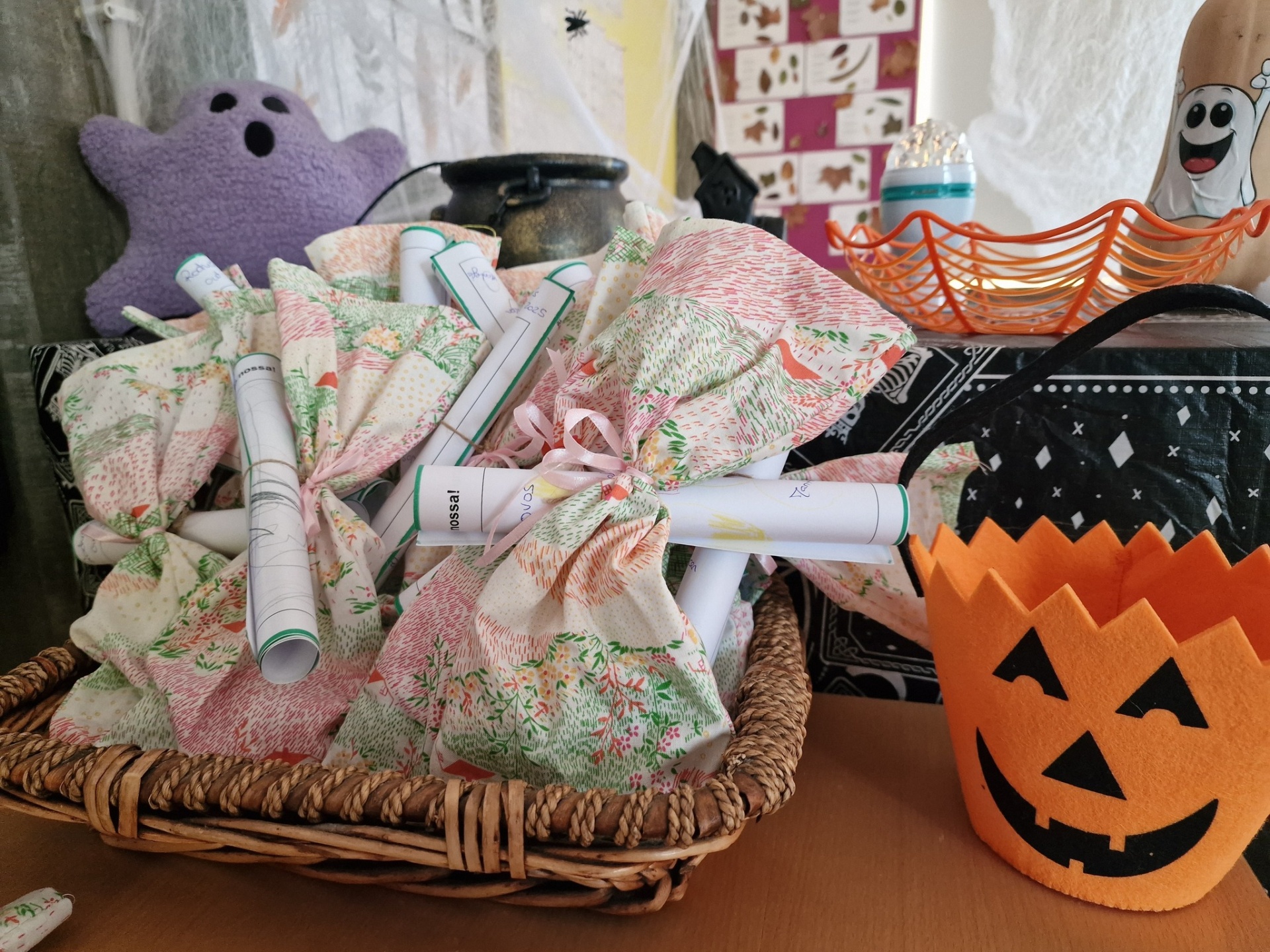 Cestos com saquinhos estampados e decoração de Halloween, incluindo balde de abóbora de feltro.