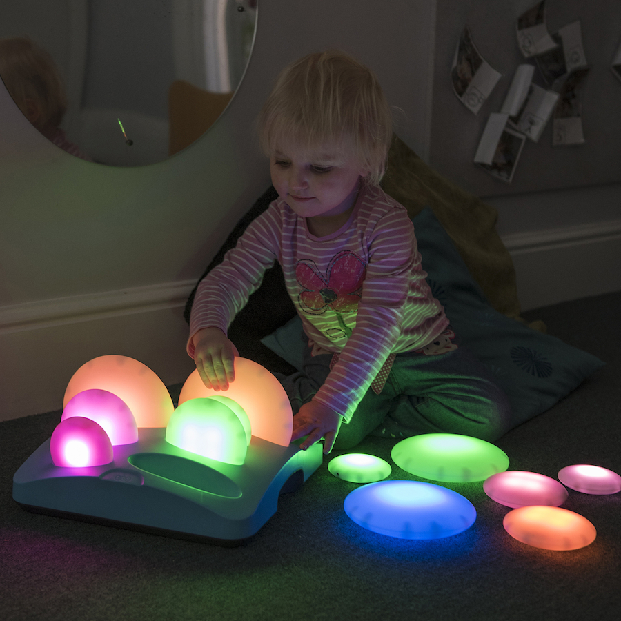 Seixos Brilhantes Criança a brincar com brinquedo de luzes coloridas em ambiente interior