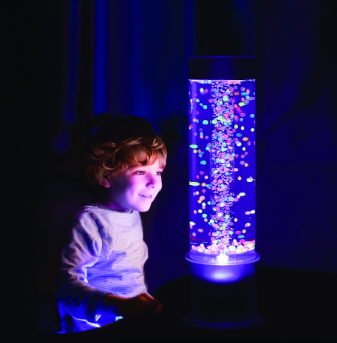 Tubo sensorial de bolhas com bolas 60 cm Lâmpada de bolhas LED cilíndrica com luzes coloridas e base branca num quarto escuro