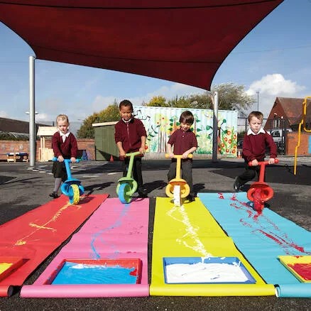 Rodas para pintura Crianças usando scooters coloridas em tapetes de pintura ao ar livre