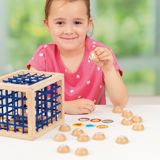 Liberta-me daqui! - As Letras Menina a jogar com brinquedo de madeira e plástico de símbolos coloridos