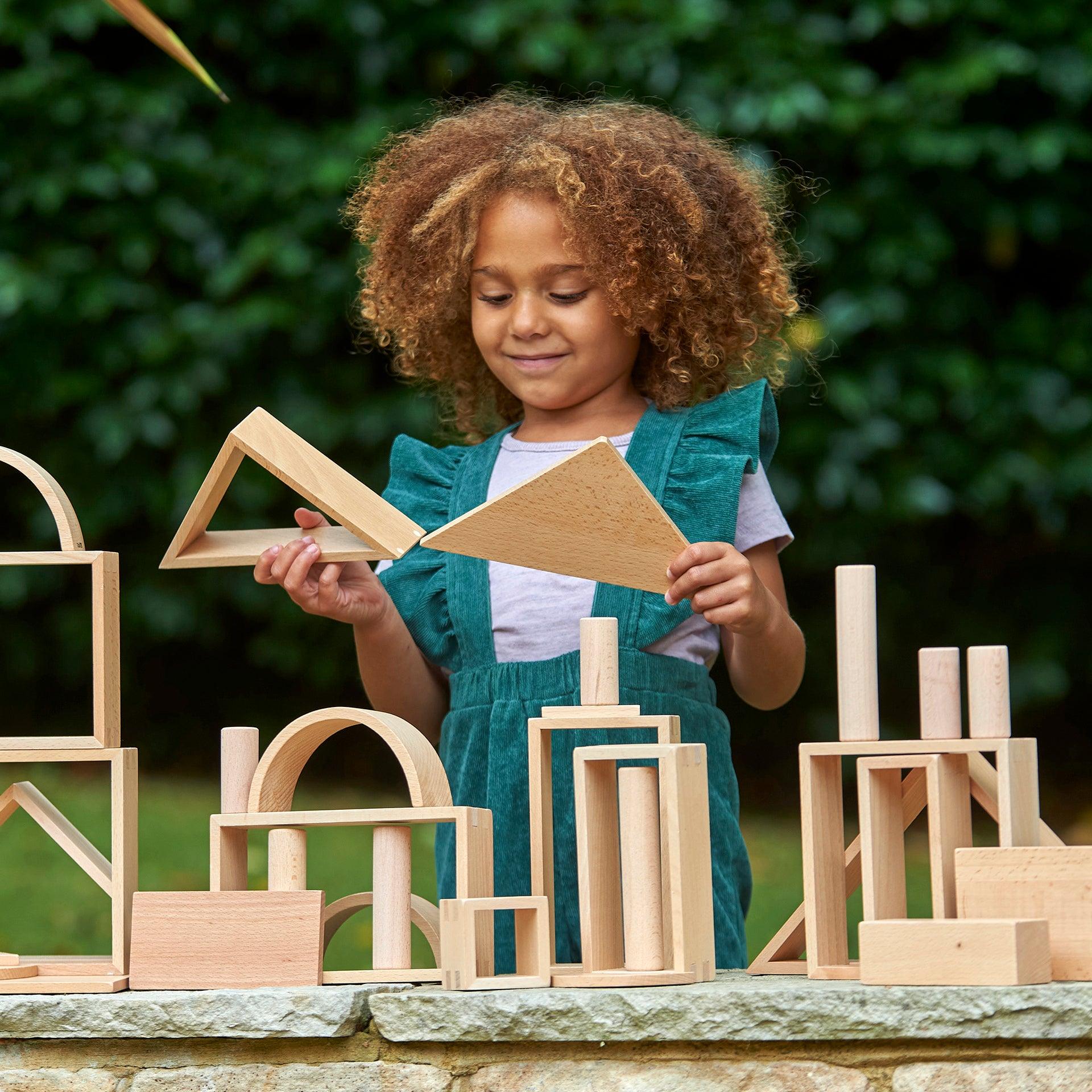 Conjunto de Painéis de Arquitetura Natural Criança a brincar com blocos de madeira ao ar livre