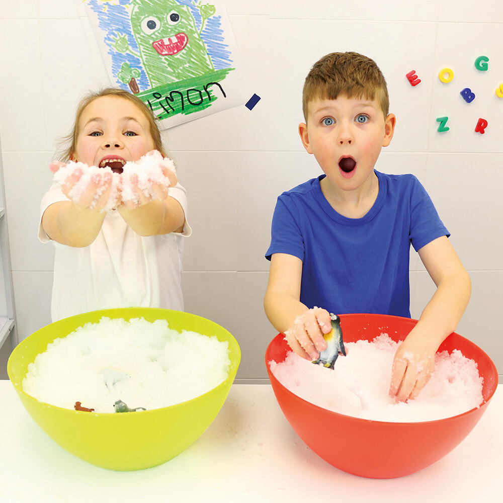 Diversão Sensorial na Neve Crianças brincando com espuma em bacias coloridas numa mesa