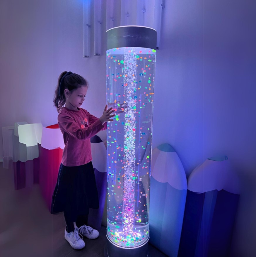 Tubo de Bolhas Extra Largo – com Bolas Flutuantes e Comando Cilindro luminoso com bolhas coloridas e criança a tocar