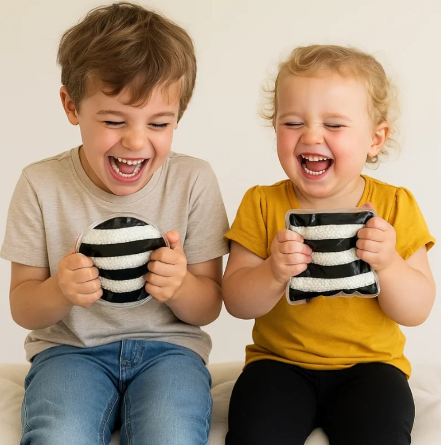 Black & White Jelly Ball Liquid Shapes – Conjunto de 4 Formas Sensoriais Duas crianças sorrindo segurando bolas macias listradas em preto e branco