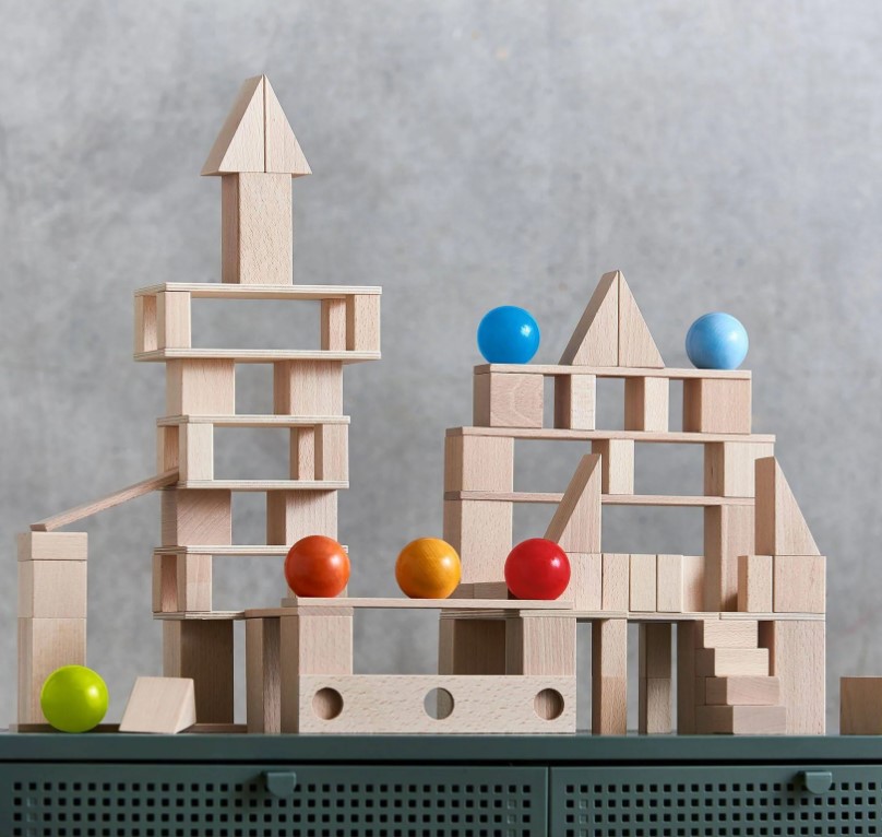 Clever Up! Building Block System 4.0 Blocos de madeira empilhados formando estruturas com bolas coloridas