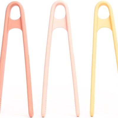 Três pinças de cozinha em rosa, bege claro e amarelo claro