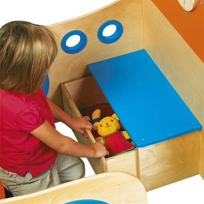 Criança a abrir gaveta de madeira com brinquedo peluche