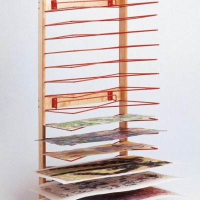 Estante de madeira com suportes vermelhos e folhas de papel artísticas