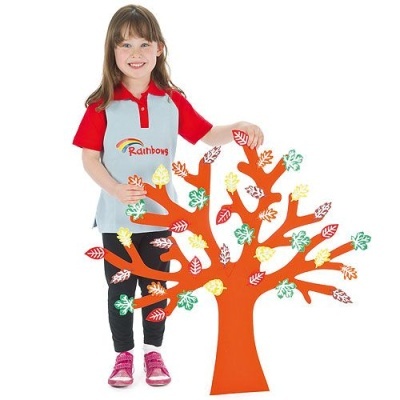 Menina segurando árvore laranja decorativa com folhas coloridas.