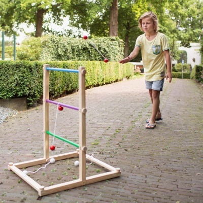 Jogo de madeira ao ar livre com menino a jogar numa calçada