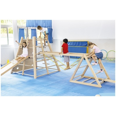 Estrutura infantil de madeira com escorrega e escadas em sala azul e branca, crianças a brincar