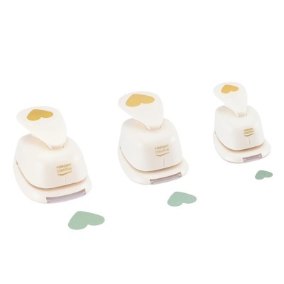 Três furadores de papel brancos com forma de coração amarelo na alavanca e corações verdes recortados