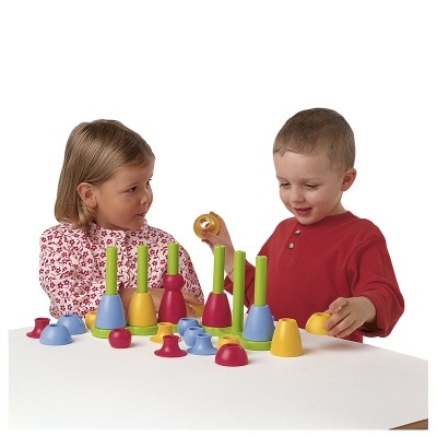 Crianças a brincar com brinquedos de encaixe coloridos numa mesa branca