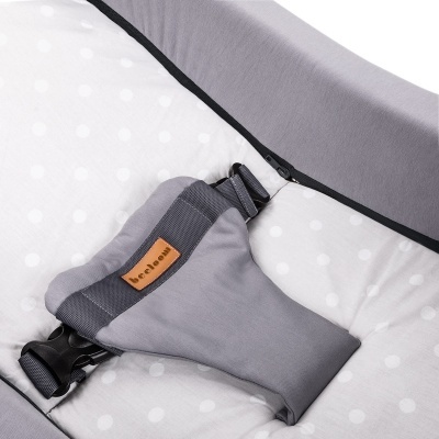 Cinto de segurança cinza com etiqueta 'brelax' sobre estofado branco com bolinhas cinzentas