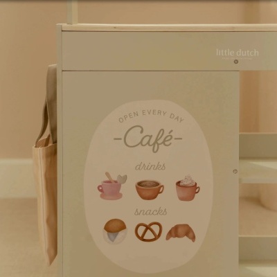 Brinquedo ou móvel infantil em madeira bege com adesivo de café e bolsa de tecido pendurada