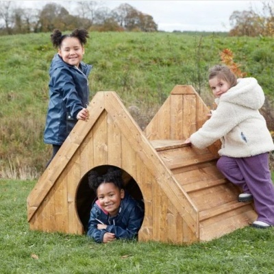 Casota de madeira triangular para crianças em relvado com três crianças a brincar