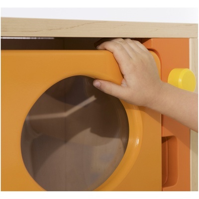 Máquina de lavar brinquedo de madeira com porta laranja e puxador amarelo, mão infantil a abrir a porta