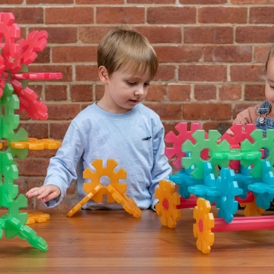 Crianças a brincar com brinquedos de construção coloridos à mesa