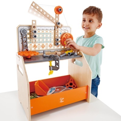 Bancada de ferramentas de brinquedo de madeira com peças coloridas e criança a brincar